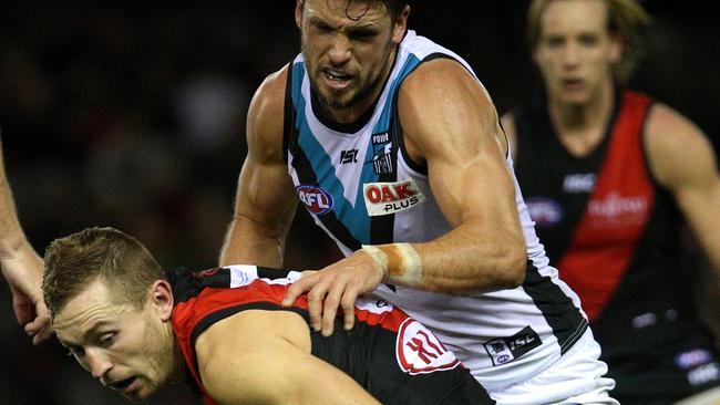 Power captain Travis Boak puts pressure on Essendon’s Devon Smith. Picture: AAP Image/Hamish Blair