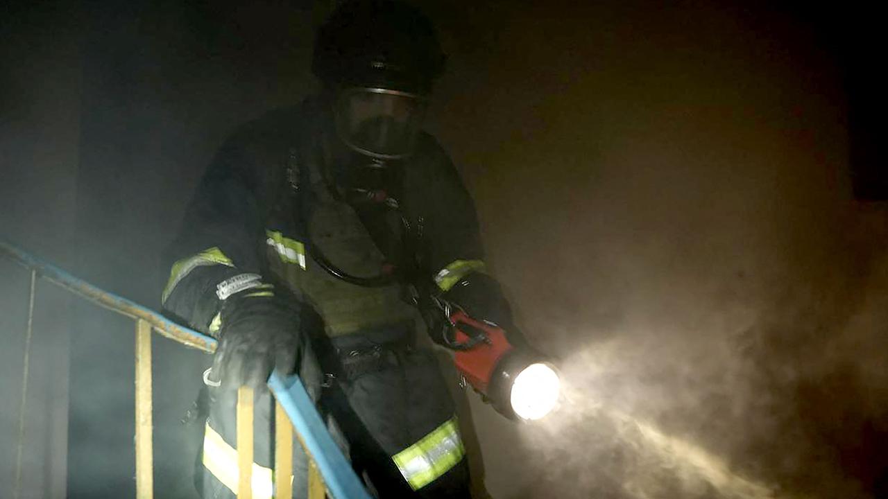 A firefighter advances in a cloud of smoke during a blaze in a residential building following Russian strikes in Kyiv. Picture: AFP.