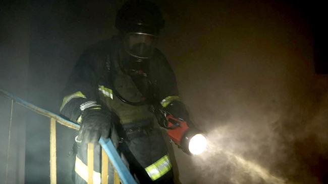 A firefighter advances in a cloud of smoke during a blaze in a residential building following Russian strikes in Kyiv. Picture: AFP.