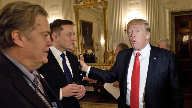 Former Trump adviser Steve Bannon, left, watches as then US President Donald Trump greets Elon Musk in the State Dining Room of the White House in 2017. Picture: Brendan Smialowski/AFP