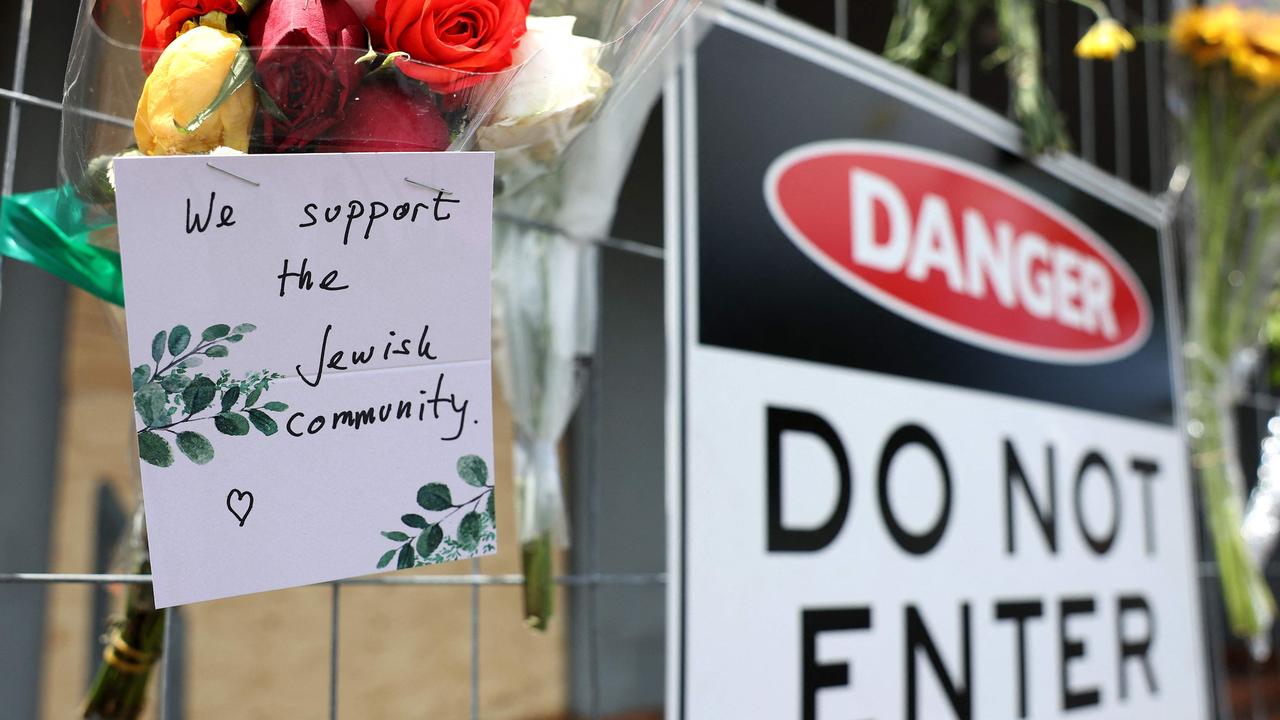 Messages and flowers are seen attached to the fence at the Adass Israel Synagogue. Picture: Martin KEEP / AFP