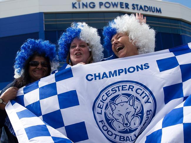 Leicester city fans celebrate outside the King Power Stadium in Leicester, central England, on May 3, 2016, after the team won the English Premier League on Monday May 2. Thousands celebrated and millions around the world watched in wonder as 5,000-1 underdogs Leicester City completed arguably the greatest fairytale in sporting history by becoming English Premier League champions yesterday. Second-placed Tottenham Hotspur's 2-2 draw at Chelsea late on Monday was enough for last year's relegation battlers Leicester to seal a scarcely credible title after outshining some of football's most glamorous teams. / AFP PHOTO / JUSTIN TALLIS