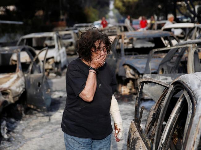 A woman reacts as she tries to find her dog, following a wildfire at the village of Mati. Picture: Reuters/Costas Baltas