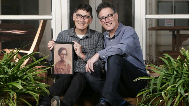 Peter (Anglicare CEO) and his twin brother John Sandeman (right) holding a portrait of their mother. Picture: Emma Brasier/AAP