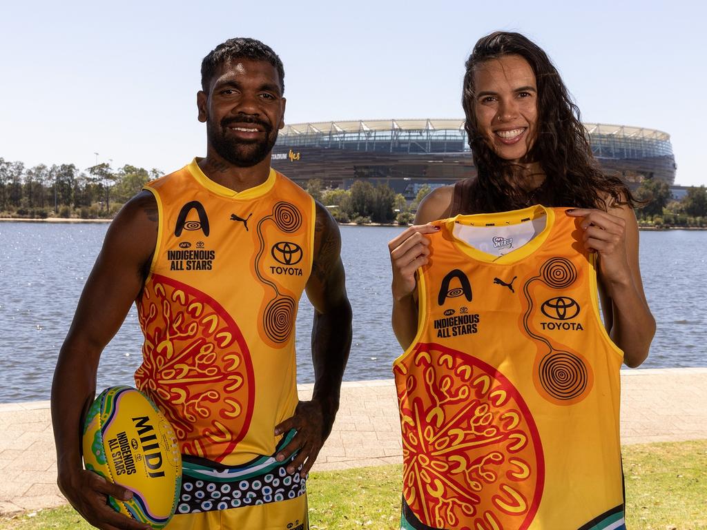 Liam Ryan and artist Jade Dolman who has designed the IAS guernsey and match sherrin, pose during the Indigenous All Stars Guernsey. Picture: Will Russell/AFL Photos via Getty Images.