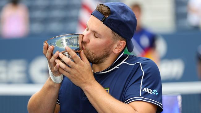 Alcott celebrates with the US Open trophy to complete his remarkable Golden Slam.