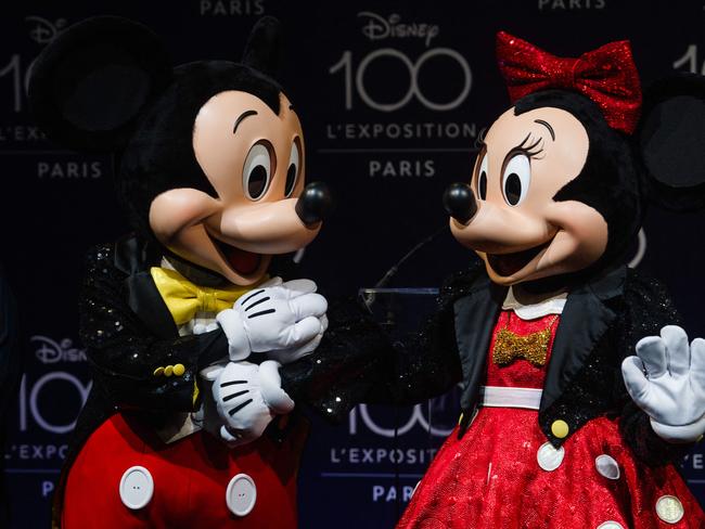 Employees, dressed as Mickey Mouse and Minnie Mouse perform during a press preview on the eve of the opening of the exhibition 