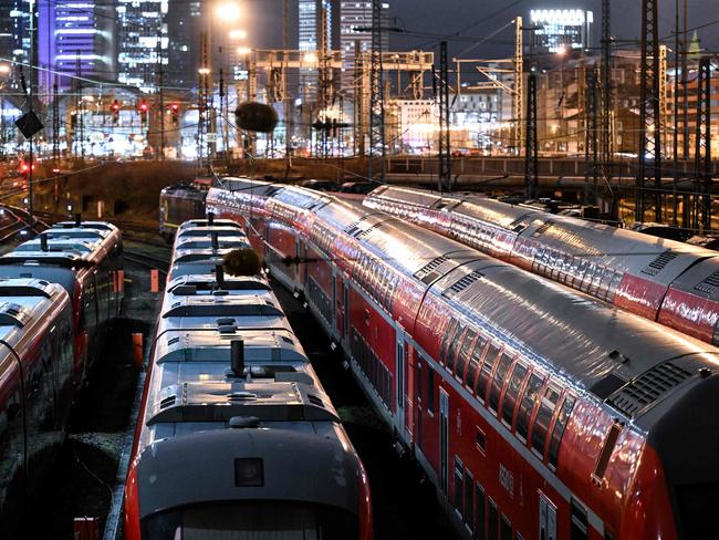 Regional trains stand still on the first day of a six-day train drivers strike on the railway tracks in Frankfurt am Main, western Germany, as in background can be seen the headquarters of the European Central Bank (ECB), on January 24, 2024. German train drivers will hold a six-day strike this week, the GDL union had announced, on January 22, 2024, the longest walkout yet in an escalating row with Deutsche Bahn over pay and working hours. The strike is due to start on early January 24, 2024, whereas the stoppage of freight services is due to begin on late January 23, 2024. (Photo by Kirill KUDRYAVTSEV / AFP)