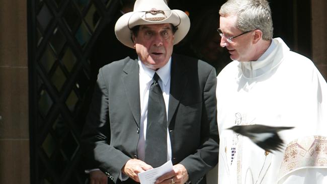 The funeral ceremony of Peter Ikin, at St Canice Catholic Church, Kings Cross. Molly Meldrum is comforted by Father Gary Perritt, Ikin's nephew. Picture Supplied