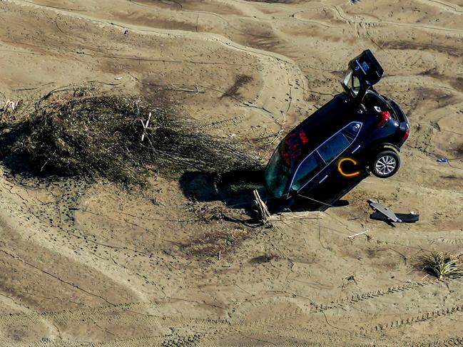 A car stuck in sand is seen in the aftermath of Cyclone Gabrielle in the Esk Valley near Napier. Picture: AFP