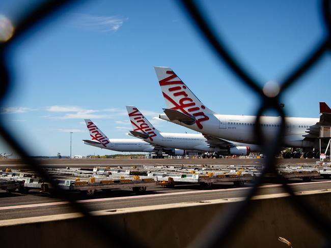 Virgin Australia aircraft are seen parked on the tarmac at Brisbane International airport on April 21, 2020. - Cash-strapped Virgin Australia collapsed on April 21, making it the largest carrier yet to buckle under the strain of the coronavirus pandemic, which has ravaged the global airline industry. (Photo by Patrick HAMILTON / AFP)