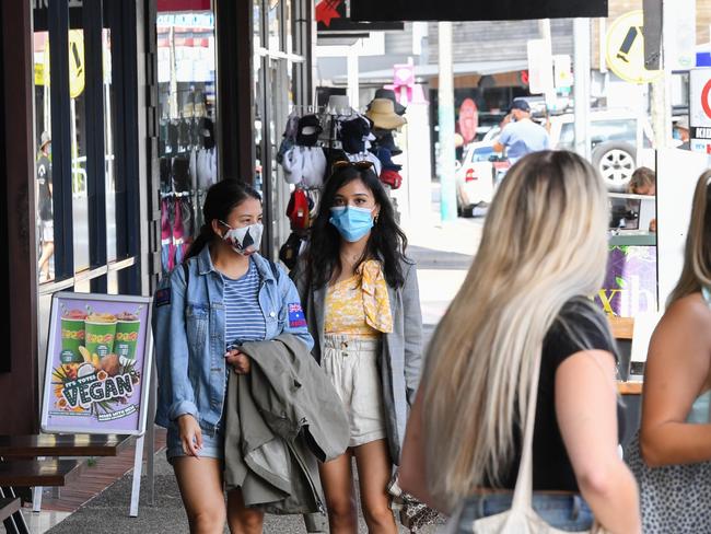 People wearing face masks in Byron Bay on Wednesday. The NSW Government has reintroduced restrictions for residents after a new COVID-19 case was recorded in the area. Picture: Getty