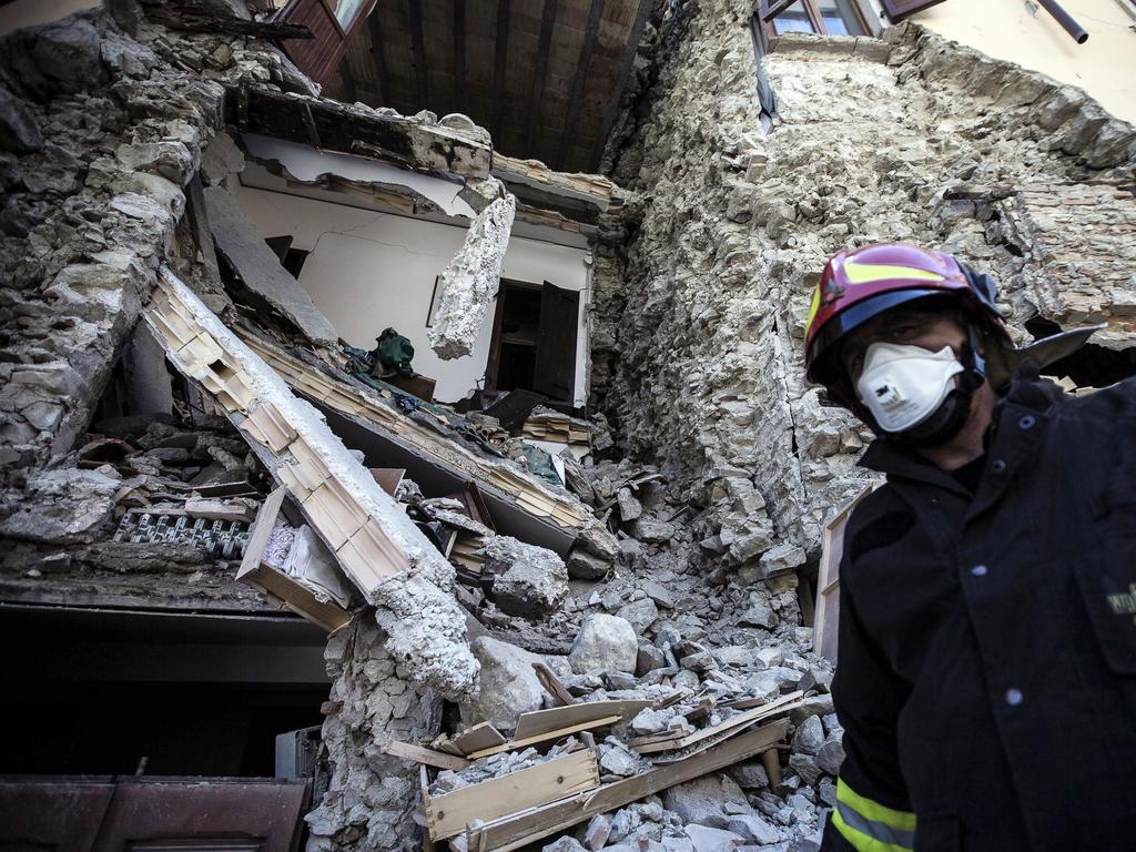 A firefighter walks past a collapsed house in Arquata, central Italy, Thursday, Aug. 25, 2016 where a 6.1 earthquake struck just after 3:30 a.m., Wednesday. Rescue crews raced against time Thursday looking for survivors from the earthquake that leveled three towns in central Italy, but the death toll rose to 241 and Italy once again anguished over how to secure its towns and cities, new and old, built on seismic lands. (Angelo Carconi/ANSA via AP)