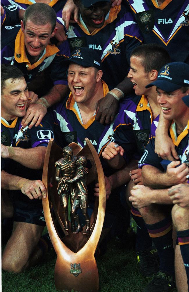 Glenn Lazarus with his Melbourne Storm players and the NRL trophy after they defeated St George-Illawarra Dragons. Photo: Gregg Porteous