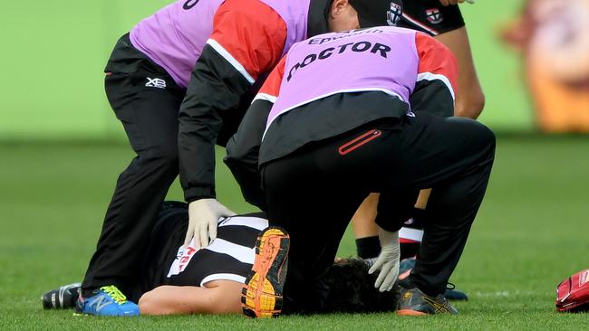 Dylan Roberton is helped by St Kilda medical staff after collapsing against Geelong last year.