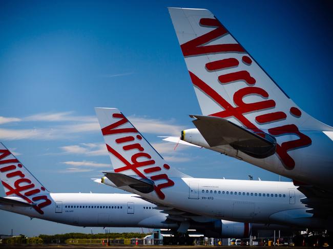 Virgin Australia aircraft are seen parked on the tarmac at Brisbane International airport on April 21, 2020. - Cash-strapped Virgin Australia collapsed on April 21, making it the largest carrier yet to buckle under the strain of the coronavirus pandemic, which has ravaged the global airline industry. (Photo by Patrick HAMILTON / AFP)