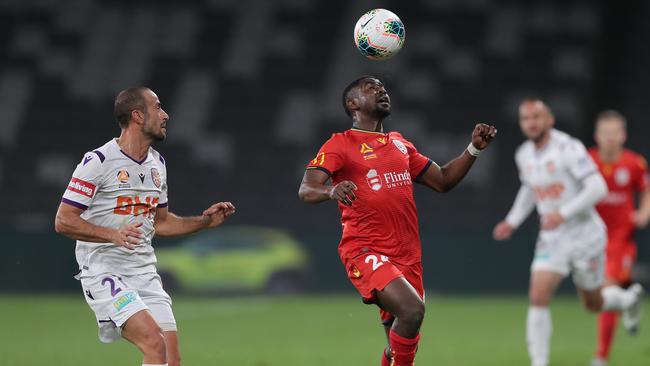 Perth’s Tarek Elrich, left, and Adelaide’s Pacifique Niyongabire compete for the ball at Bankwest Stadium in Sydney on Thursday night. Picture: Getty Images