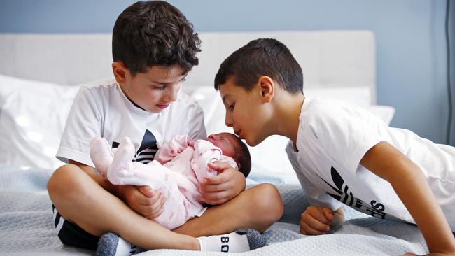 Michael holds his new baby sister as Alex plants a kiss on her head. Picture: Sam Ruttyn