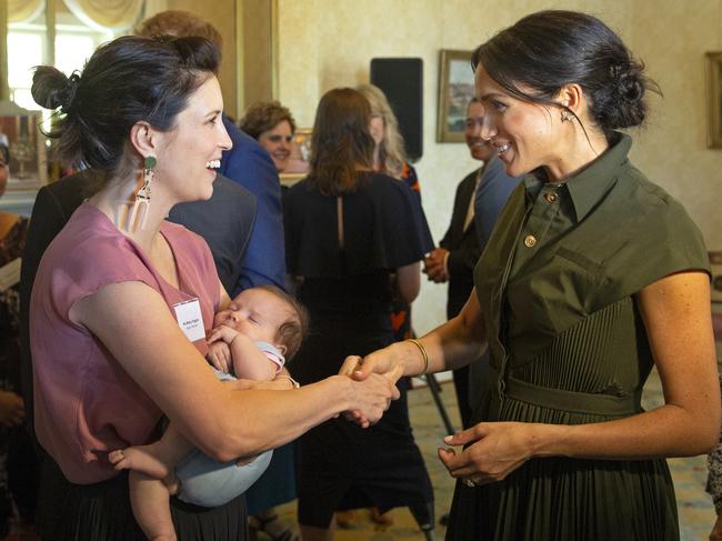 Meghan speaks with Australian singer Missy Higgins, who is holding nine-week-old baby Luna. Picture: AP Photo/Steve Christo