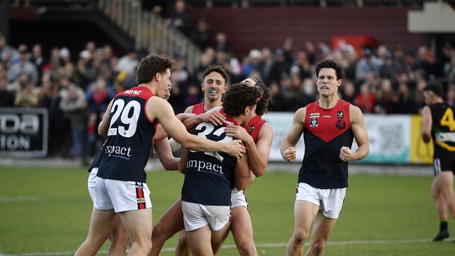 Lachlan Williams is embraced by Mt Eliza teammates after kicking a goal in the grand final. Picture: Andrew Batsch