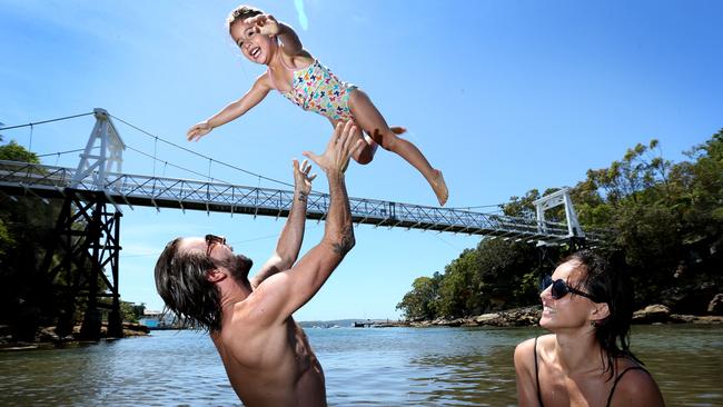 Mitchell and Rachel Farmer with their daughter Willow, cool off in the calm waters of Parsely Bay. Picture: Richard Dobson