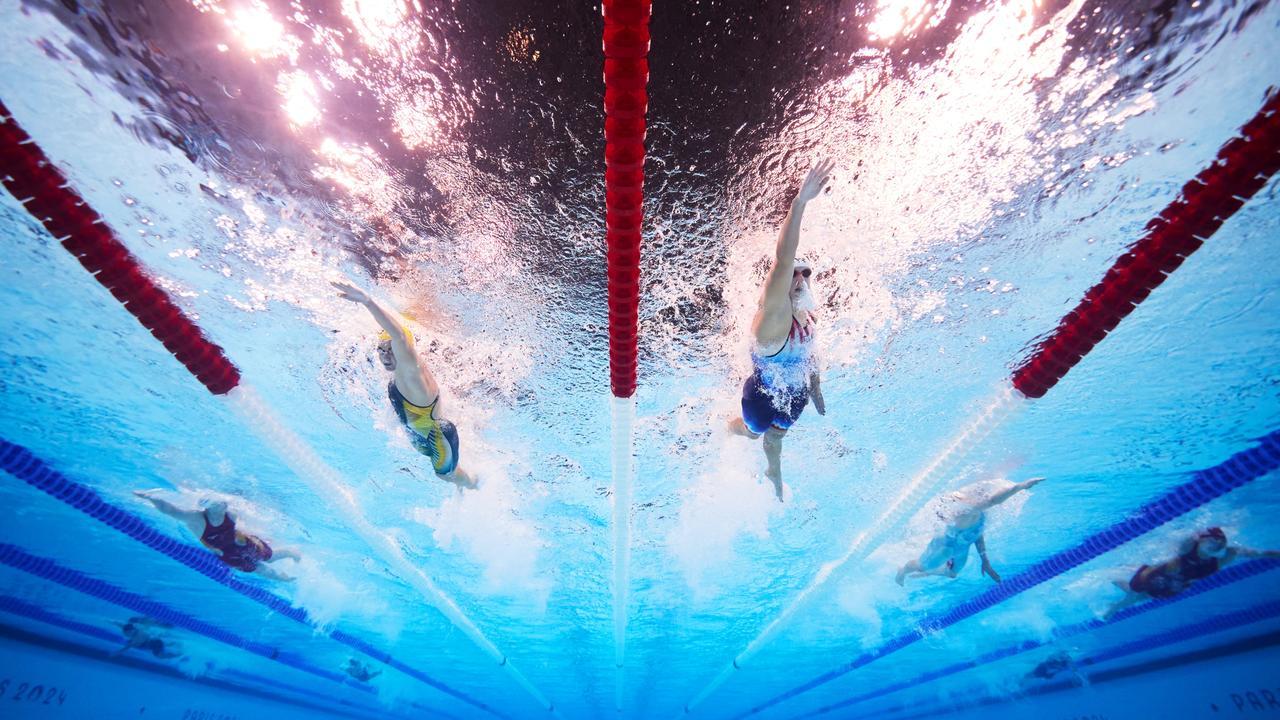 Australian swimmer Ariarne Titmus creeps up behind American swimmer Katie Ledecky on day one of the Paris Olympic Games. Picture: Adam Pretty/Getty Images