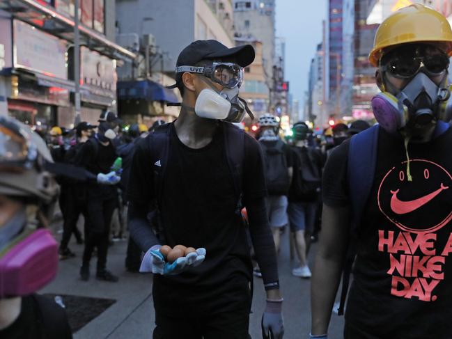 A pro-democracy protester holds eggs which he plans to throw at a police station in Hong Kong. Picture: AP