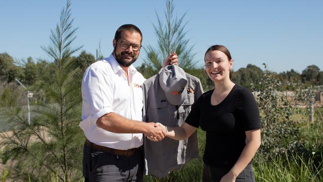 Sydney Zoo managing director Jake Burgess hands a new uniform over to employee Dana. Picture: Supplied