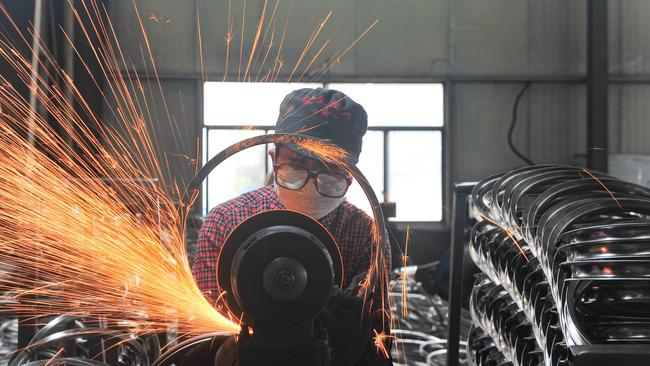 A worker welding wheels at a factory in Hangzhou in China’s eastern Zhejiang province. Picture: AFP