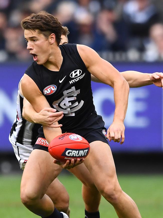 Liam Stocker handballs during his AFL debut against Collingwood.