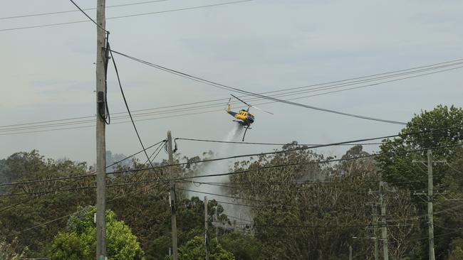 Helicopters are seen water bombing a bushfire at Northmead on Sunday afternoon. Jenny Evans/Getty Images