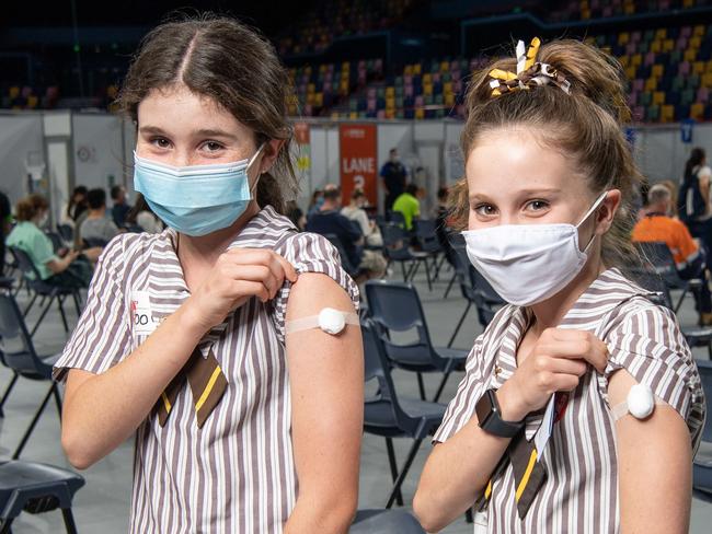 14-09-2021 Sisters Nina ,15, and Romy ,13, Vickers after receiving their first Pfizer vaccination from midwife / registered nurse at the Brisbane Entertainment Covid19 Vaccination Hub in Boondall. PICTURE: Brad FleetMum Kate 0412154201Nina has blue face mask