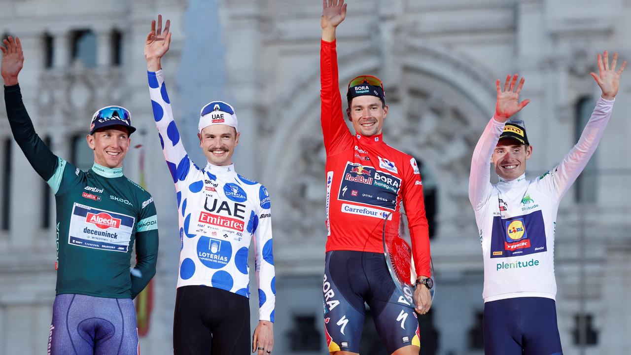 (From L) Team Alpecin's Kaden Groves, Team UAE's Jay Vine celebrates, overall leader Team Bora's Primoz Roglic and Team Lidl-Trek's Mattias Skjelmose celebrate on the podium after the last stage of the Vuelta a Espana, a 24,6 km time-trial race between Madrid and Madrid, on September 8, 2024. (Photo by OSCAR DEL POZO / AFP)