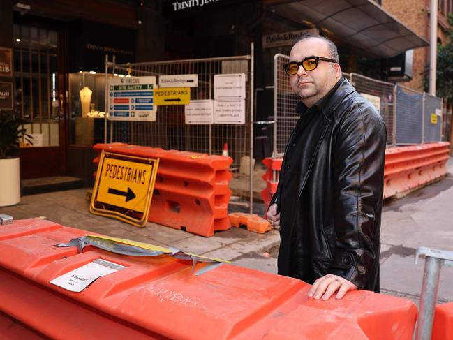 Mr Harry shows how obscured his shopfront currently is. Picture: Rohan Kelly