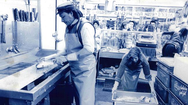 A stallholder at the market preparing fish for sale.