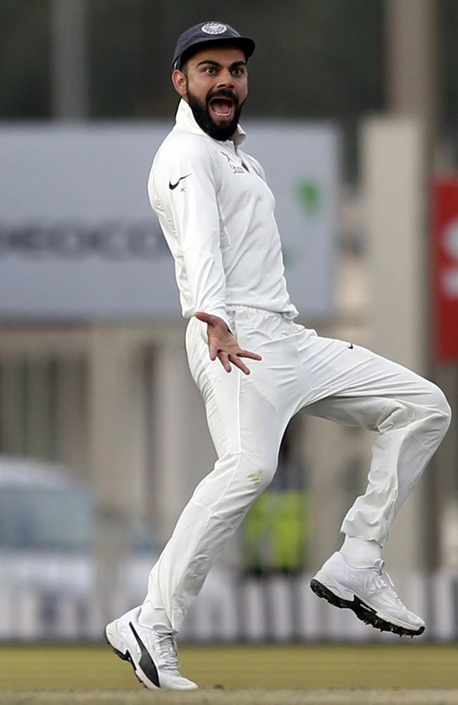 India's captain Virat Kohli gestures towards Australia's Matt Renshaw as he runs to celebrate the dismissal of David Warner.