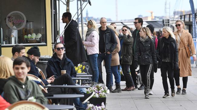 People line up to buy ice cream in Stockholm in April. Picture: AFP