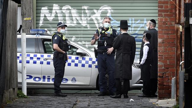 Police speak to locals near the synagogue in Ripponlea. Picture: Andrew Henshaw