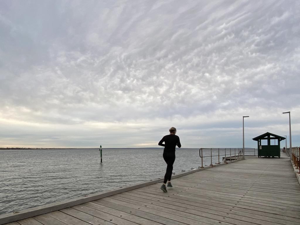 A local runs along the Mordialloc harbour in Melbourne. Picture: Michael Dodge