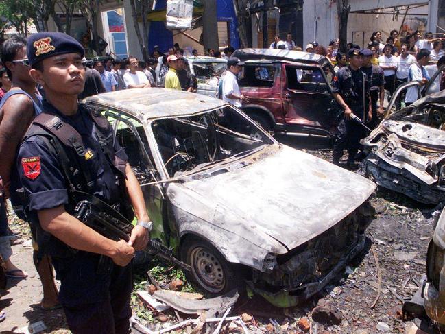 Indonesian elite police officers of Mobile Brigade stand guard near wreckages of cars at the site where an explosion went off in Denpasar, Bali, Indonesia. Picture: AP