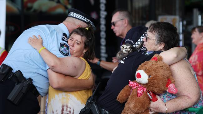 Police receive a hug from local residents at the Town Square Redbank Plains shopping centre where a grandmother died from stab wounds. Picture: Liam Kidston