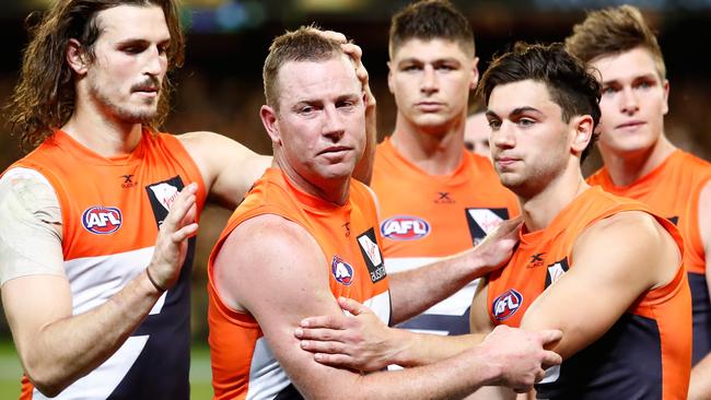 Steve Johnson is congratulated by Phil Davis and Tim Taranto after his final AFL game.