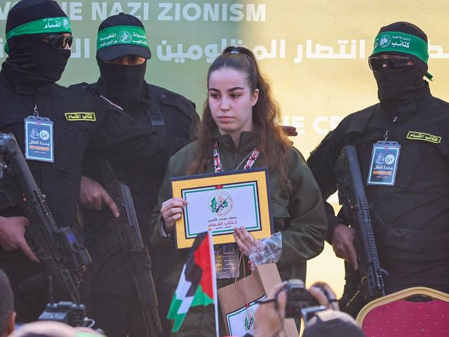 Hamas militants escort Israeli hostage Agam Berger (C) on a stage before handing her over to a Red Cross team in Jabalia. Picture: Omar Al-Qattaa/ AFP