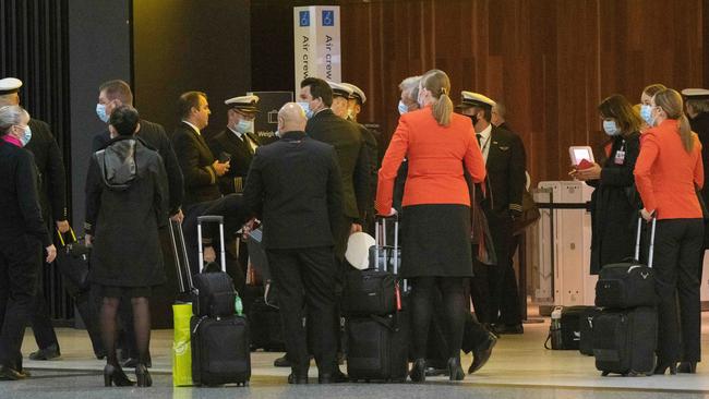 Flight staff gather at Melbourne Airport’s Terminal 2 on Sunday after it was declared an exposure site overnight. Picture: Tony Gough