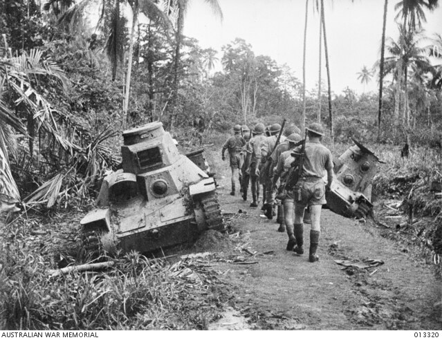 Australian troops advance past the bogged Japanese light tanks at Milne Bay in 1942. Picture: Australian War Memorial