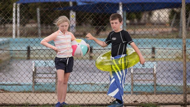 The local pool, which residents are trying to save, is now filled with muddy floodwater that kids like Lacey, 9, and her brother Taylor, 11, Murray will not be able to use. Picture: David Caird