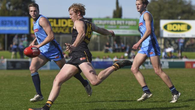 Glenelg's Josh Scott sinks the boot in. Picture: Naomi Jellicoe