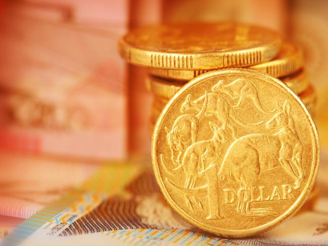 Australian Dollar Coin.  Note this is a circulated coin so has some nicks and scratches.  Stock image of a pile of Australian dollars with Australian money in background generic