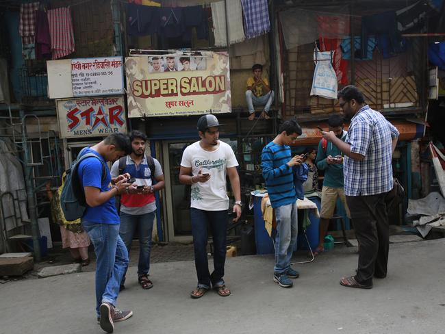 Young Indians look at their screens as they play Pokemon Go in Mumbai. Picture: Getty
