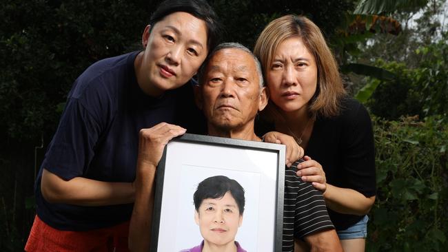 Sisters Na Xue and Fei Xue with their father Zumu Xue who lost their mother and wife Yagin Han who died on a treadmill at hospital. Picture Lachie Millard